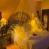 The Mexican Inn in Cabo San Lucas bedroom with canopy bed, mosquito net, warm lamps and carved wardrobe