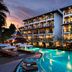 Centara Anda Dhevi Resort & Spa Krabi in Ao Nang with illuminated pool and palm trees at dusk