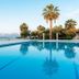 Calamos Beach Family Club pool with sea view and palm trees in Agii Apostoli