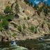 Buffalopeaks Lodge in Buena Vista overlooking a rocky riverbank with kayakers and pine-covered cliffs