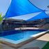 Central Motel Mildura pool with blue shade sails and palm fronds in Mildura