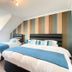 Rosebank Guest House in Perth guest room with twin beds, striped feature wall and window seating