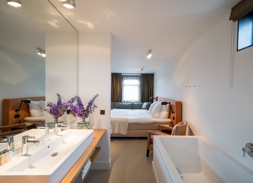 Bij Jef in Den Hoorn bathroom with double sink, freestanding tub, and view into the bedroom
