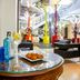 Pestana Curitiba lobby with glass table, drinks and plated appetizers, modern seating area