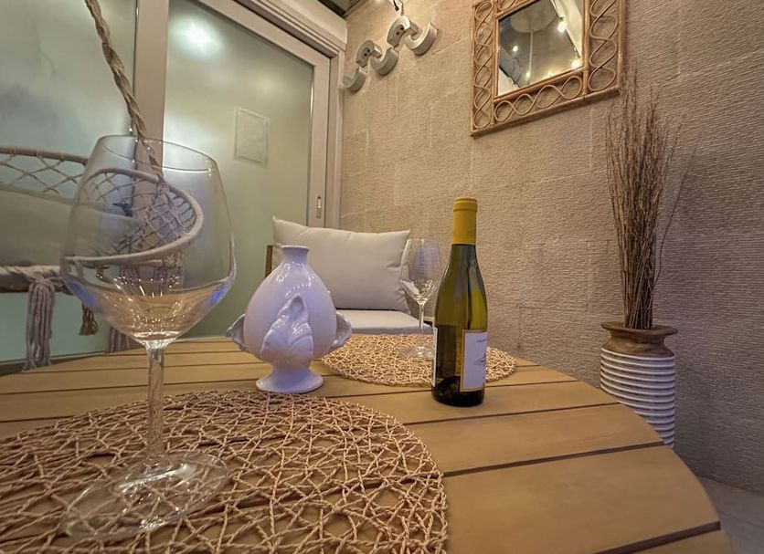 Vingt Sept in Polignano a Mare: cozy terrace table with wine bottle, glasses, and decorative lantern