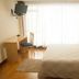 Hotel La Ronda in Castro-Urdiales bedroom with bed, desk, chair, wall TV, and bright window
