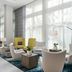 Courtyard by Marriott Delray Beach lobby seating area with white chairs, tables and tall windows in Coral Springs