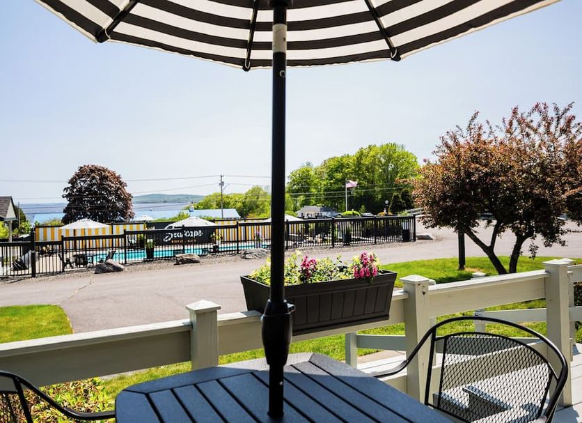Seascape Motel & Cottages in Belfast with patio seating, umbrella, and distant waterfront view