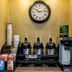 Red Roof Inn Tinton Falls-Jersey Shore breakfast station with coffee dispensers, snacks, and wall clock