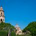 Fiesta Inn Morelia Altozano in Morelia with cathedral towers above lush trees