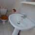 Au Pied Levé in Trévron bathroom with toilet, pedestal sink and tiled floor