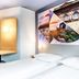 B&B Hotel Kaiserslautern guest room with twin beds, desk, stools and wall art