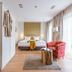 Tides Boutique Hotel in Norden guest room with king bed, armchair, floor-to-ceiling curtains and wood accents