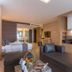 Kudo Hotel & Beach Club Patong suite with seating area, bed, kitchenette and TV