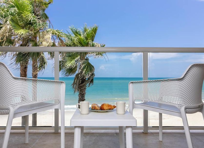 Ocean Breeze Inn Vero Beach balcony with chairs, table, and ocean view in Vero Beach