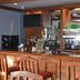 Quality Inn Perrysburg hotel bar with wooden counter, liquor shelves and two wall-mounted TVs