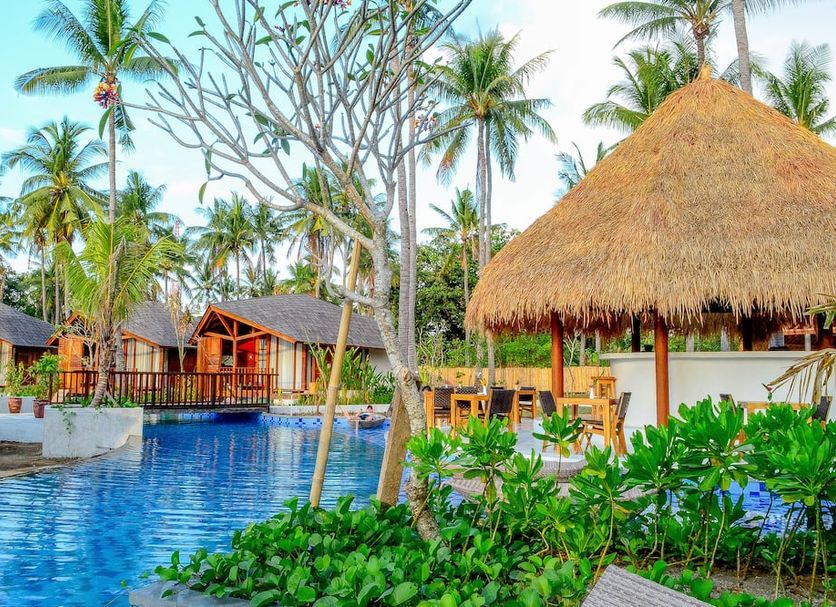 Gili Air Lagoon Resort By Waringin Hospitality in Pemenang with tropical pool, palm trees and thatched pavilion