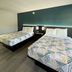 Studio 6 Suites Lafayette in Lafayette guest room with two beds and teal accent wall