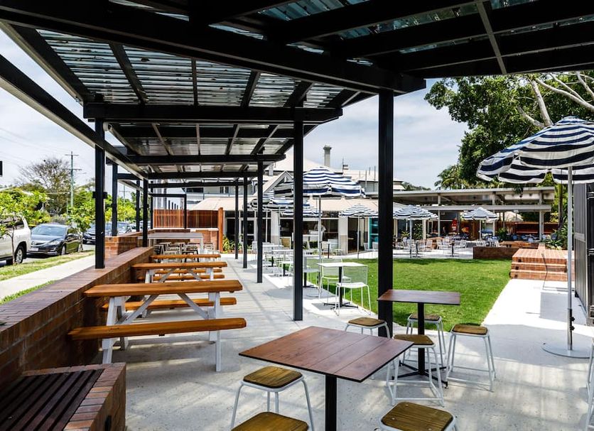 The Waterloo Bay Hotel in Brisbane with shaded outdoor seating, picnic tables and grassy courtyard