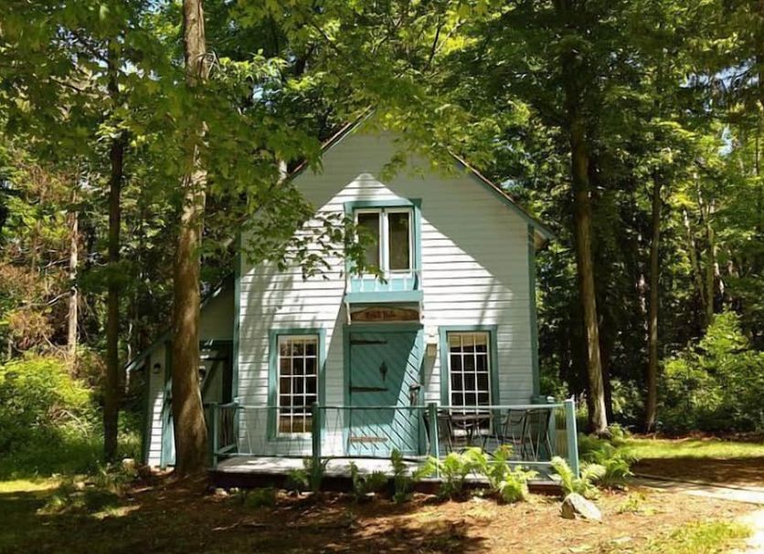 Harbor Light Inn in Ellison Bay, a quaint white cottage-style building surrounded by trees