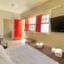 Hospedagem Central in Tiradentes room with red balcony door, wall TV, and neatly made bed