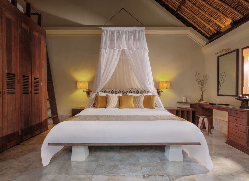 Mimpi Resort Menjangan in Gerokgak: bedroom with canopy bed, wooden furnishings, and thatched ceiling