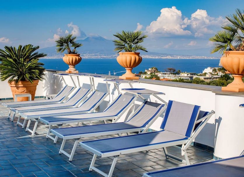 Hotel Zi' Teresa in Sorrento: rooftop terrace with sun loungers, potted palms, and sea views