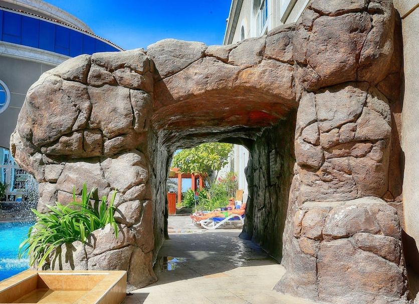 Sharjah Premiere Hotel & Resort in Sharjah, rock archway by the pool with resort seating