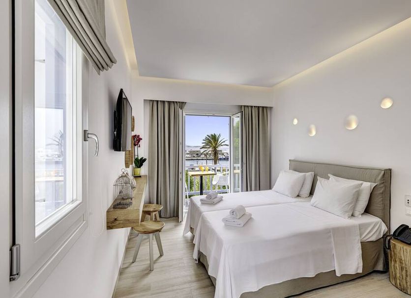 Makis Place in Tourlos bedroom with twin beds, balcony doors and a view of palm trees and the sea