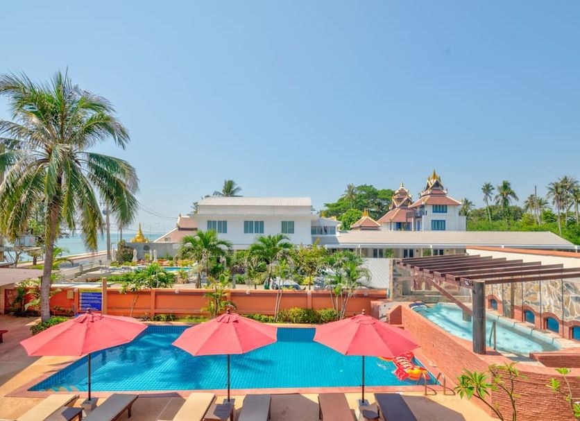 Palm Beach Resort in Pak Nam Pran with poolside red umbrellas, palm trees, and resort buildings