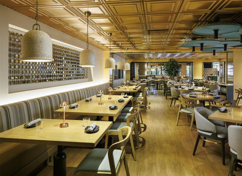Hyatt Regency Greenville restaurant with tables, booth seating, and warm modern lighting