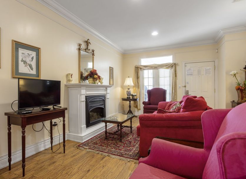 Edgewater Inn - Biloxi Beach living room with red sofas, fireplace, TV and window seating