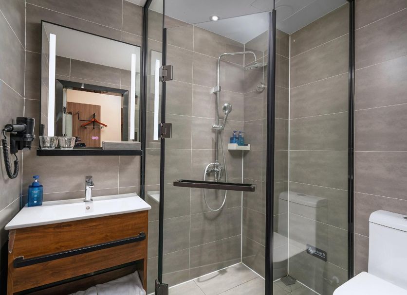 Hanting Hotel Dongguan Changan Wanda bathroom with glass shower, vanity and toilet in Dongguan
