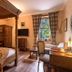 The Whispering Pine Lodge in Spean Bridge: cozy wood-paneled guest room with four-poster bed and desk