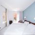 Hotel Plaça room in Sant Feliu de Guíxols with twin beds, blue accent wall and balcony doors