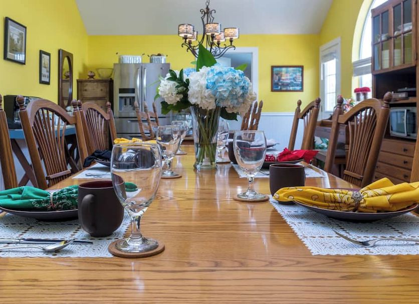 Yellow House B&B in Salado dining room set for a meal with a long wooden table and yellow walls