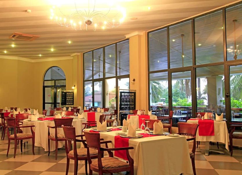 The Kairaba Beach Hotel in Serrekunda with a bright dining room and large windows overlooking greenery