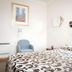 Trafalgar Lodge Nelson guest room with patterned bed, blue armchair, window and wall art