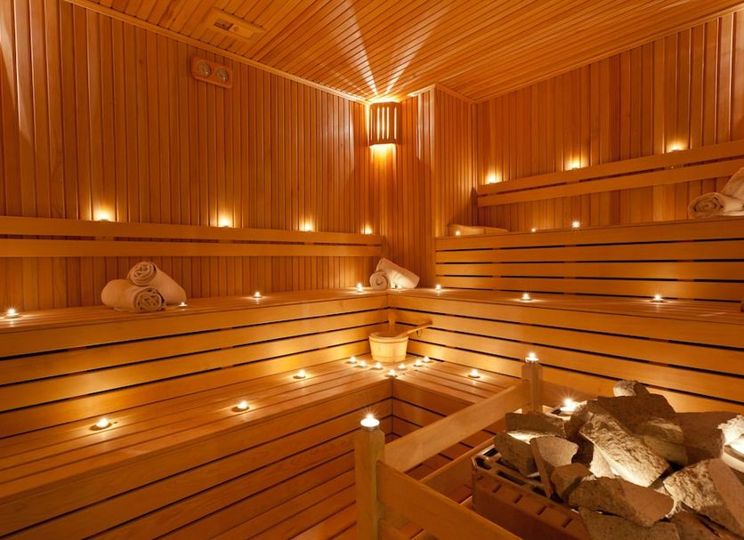 Gardenia Beach Hotel in Alanya sauna with wooden benches, candles, and a central heater