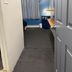 The Macaw Guesthouse in New York hallway with blue wall, gray curtain, and small shelf by the door