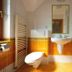 Penzion Snezienka bathroom in Tatranska Lomnica with shower, sink, toilet and orange tile