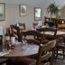 Dining room at Winchelsea Lodge in Winchelsea with wooden tables, chairs, and set place settings