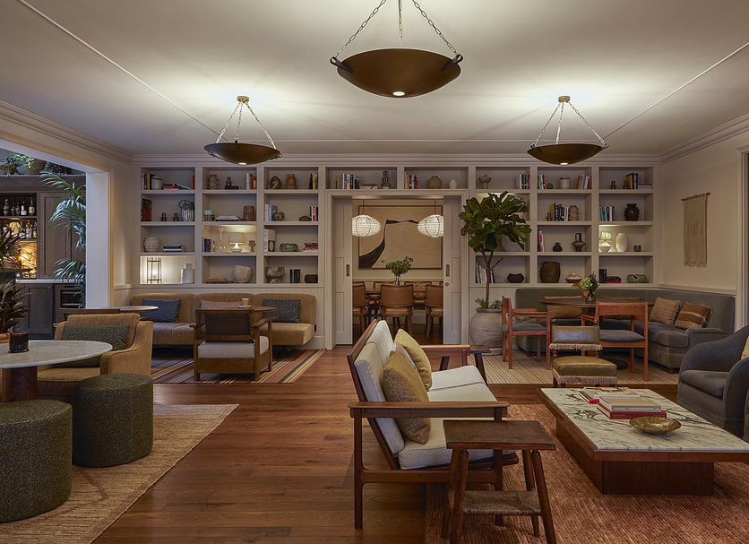 Miiro Borneta Barcelona lounge with bookshelves, sofas, wood floors and a central coffee table