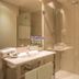 SM Hotel Teatre Auditori bathroom with sink, mirror, glass shower and lit candle in Barcelona