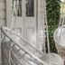 Cove Studios Byron Bay hanging chair on a shaded balcony beside white French doors