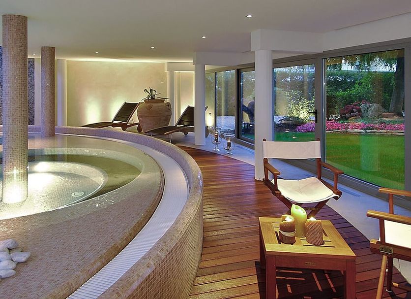 Terme Europa in Abano Terme spa area with circular indoor pool and lounge chairs by garden windows