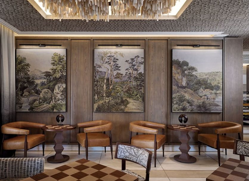 The Winston Hotel Johannesburg lounge with leather chairs, side tables and scenic wall art