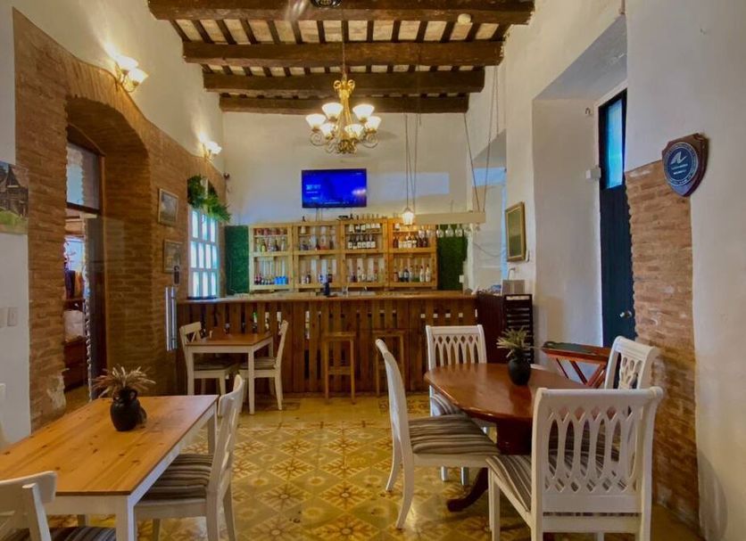 Dona Elvira Boutique Hotel in Santo Domingo dining room with wood bar, tiled floor and chandelier