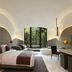 The Roseate New Delhi guest room with arched ceiling, double bed, and garden view