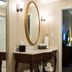 The Mount Vernon Grand Hotel bathroom vanity with oval mirror, wall sconces, and towels in Mount Vernon